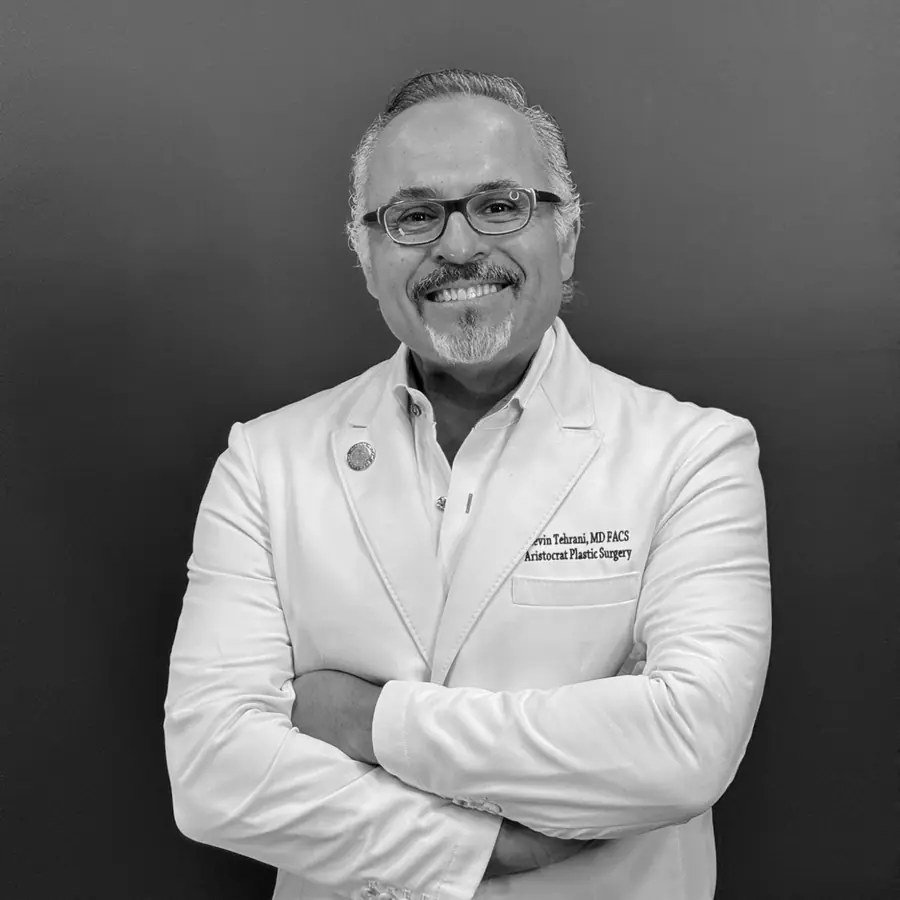Dr. Kevin Tehrani in a white coat, arms crossed